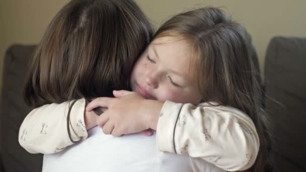 Waking up little girl in pajamas happily hugs her mother. — Stock Video