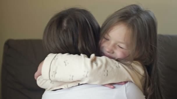 Despertando niña en pijama felizmente abraza a su madre. — Vídeos de Stock