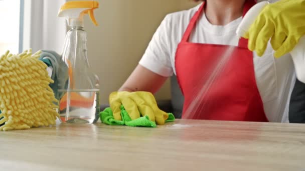 Frau in Schürze und Schutzhandschuhen wäscht und poliert die Arbeitsplatte gründlich. Anstrengende Arbeit. — Stockvideo