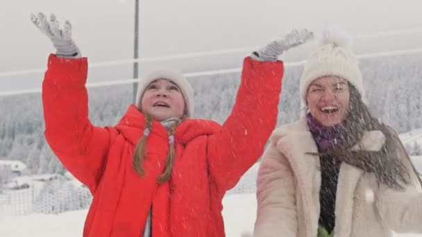 Ung kvinde leger med sne med sin teenagedatter. Sjov familietid. Vinterferie. – Stock-video