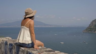 Genç bayan turist deniz ve dağların güzel manzarasına hayran. İtalya 'da yaz.