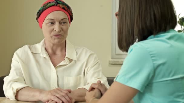 Paciente con cáncer mujer que usa un pañuelo en la cabeza después de la quimioterapia consulta con un oncólogo. — Vídeos de Stock
