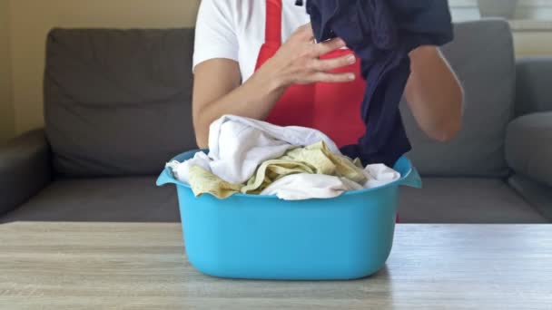 The housewife prepares to wash delicate items. The woman is holding a basin of laundry. — Stock Video