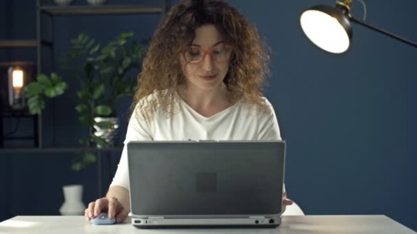 Портрет женщины средних лет, работающей за ноутбуком. Она сосредоточена и заботлива. Дистанционная работа. — стоковое видео
