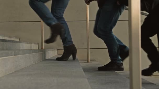 Pernas de pessoas diferentes descendo as escadas de uma passagem subterrânea ou metrô. — Vídeo de Stock