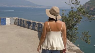 Genç bayan turist deniz ve dağların güzel manzarasına hayran. İtalya 'da yaz.