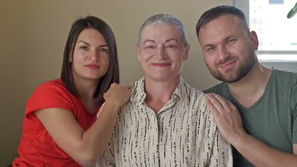 Familie portret. Volwassen zoon en dochter knuffelen een oudere moeder. Gezinswaarden. — Stockvideo