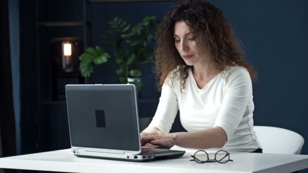 Laptopta konsantre olarak çalışan güzel bir kadının portresi. Kadın yaptığı işin sonucundan memnun.. — Stok video