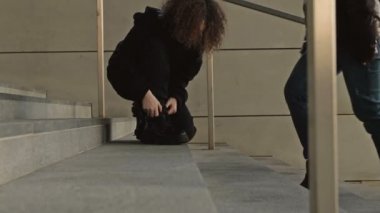 Farklı insanların ayakları aşağı iner ve bir alt geçidin ya da metronun merdivenlerinden yukarı çıkar. Kızların ayakkabı bağı çözülmüştü. Herkes işini aceleye getiriyor..