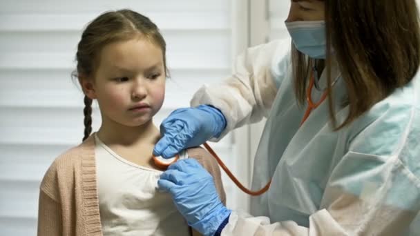 Ärztin hört einer Patientin im Alter von 7-8 Jahren mit einem Phonendoskop zu. Kinderheilkunde. — Stockvideo
