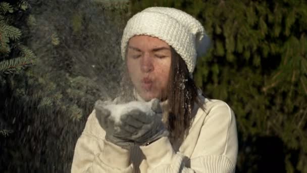 Jeune femme joyeuse en vêtements légers se réjouit dans la première neige et joue dans la forêt. — Video