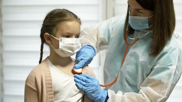 Médica escuta com um fonendoscópio uma paciente de 7-8 anos de idade. Pediatria. — Vídeo de Stock