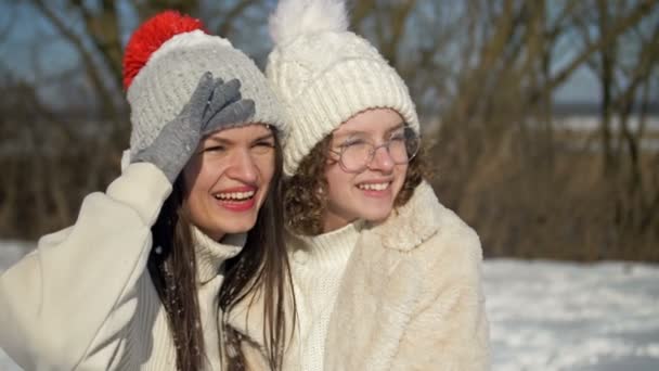 Young woman and her teenage daughter are having fun on a winter walk. Sunny day, family vacation. — Wideo stockowe