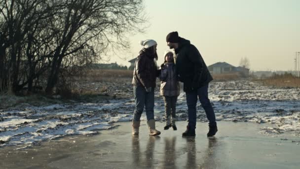 Dad, mom and daughter 7-8 years old are walking on the ice in a frozen lake. Everyone is kissing each other with love. Family values. — Vídeo de Stock