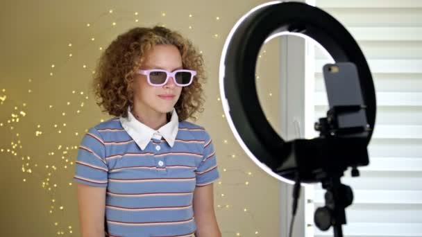 Cheerful girl blogger shows a poster with one million subscribers to the camera. The teen brags about his accomplishments to subscribers. — 图库视频影像