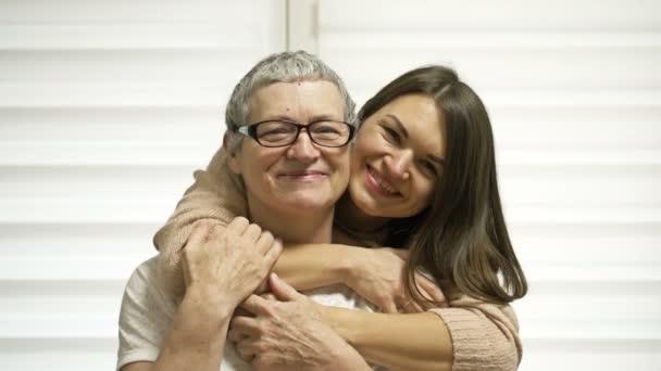 Dospělá dcera objímá svou matku. Starší žena má opětovný růst vlasů po chemoterapii. Láska, péče a podpora v rodině pacienta s rakovinou. — Stock video