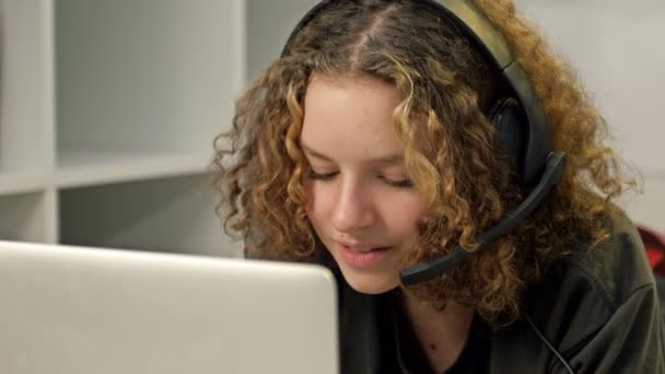 Nastolatka uśmiechający się za pomocą laptopa i noszenie słuchawek, koncepcja technologii i wypoczynek. — Wideo stockowe