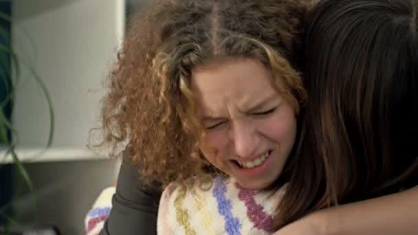 Teenage girl is crying bitterly on the shoulder of her mother or friend. — Stok video