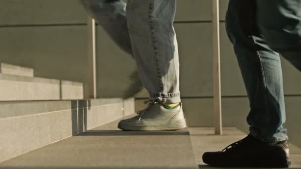 Os pés de pessoas diferentes correm pelas escadas de uma passagem subterrânea ou metrô. — Vídeo de Stock