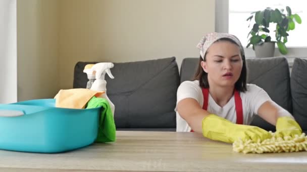 Молодая домохозяйка устала от домашней работы. Перегруженная работой женщина в окружении чистящих средств, отдыхающих от работы. Концепция домашнего хозяйства. — стоковое видео