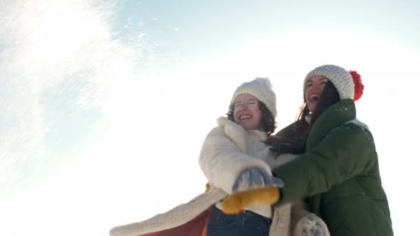 Linda adolescente y su hermana mayor o mamá están jugando con la nieve durante un paseo de invierno. — Vídeos de Stock