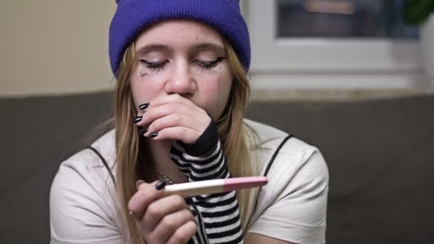Teenage dívka se dívá na výsledek těhotenského testu a pláče. Sociální problém. — Stock video