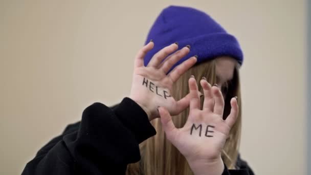 Teenagermädchen bedeckt ihr Gesicht mit ihren Handflächen mit der Aufschrift HELP ME.