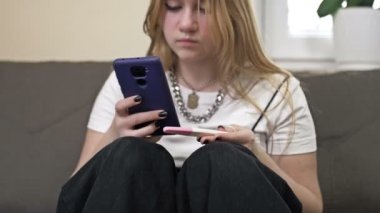 Genç kız elinde hamilelik testi tutuyor ve cep telefonuyla fotoğrafını çekiyor. Gençlik hamileliği.