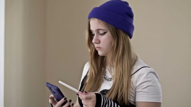 Bang en boos tienermeisje neemt een foto van een zwangerschapstest op een mobiele telefoon. Tienjarige zwangerschap. — Stockvideo