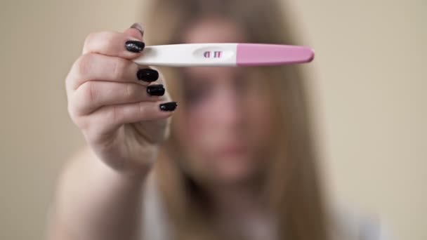 Adolescente montre un test de bande pour la grossesse. Deux lignes, résultat positif. Grossesse des adolescentes. — Video