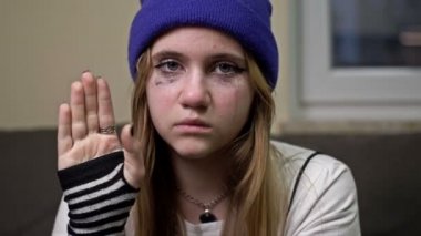 Ağlayan genç bir kız yardım istiyor. Yardıma ihtiyacı olan insanları gösteren bir jest..