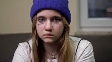 Ağlayan genç bir kız yardım istiyor. Bir insanın yardıma ihtiyacı olduğunu gösteren bir jest. Şiddet ve kız istismarı teması..