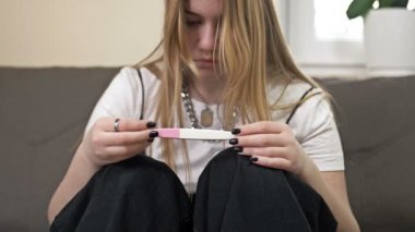 Genç kız hamilelik testine korkunç bir şekilde bakıyor..