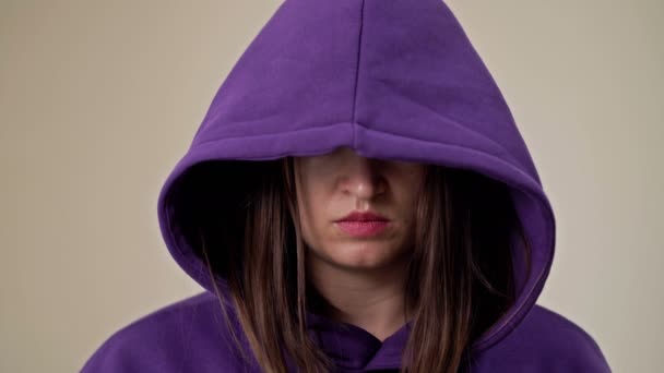 Woman covering her face with a hood demonstrates a gesture indicating a persons need for help. — Stock Video