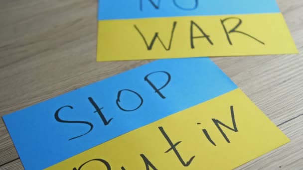 Плакаты с изображением украинского флага и слоганами NO WAR и STOP PUTIN. — стоковое видео