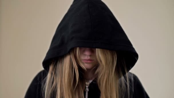 Девочка-подросток, прикрывая лицо капюшоном, показывает ладони с надписью "Помогите мне". — стоковое видео