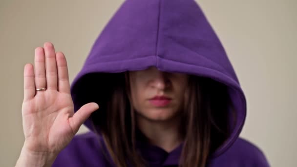 Vrouw die haar gezicht bedekt met een kap demonstreert een gebaar dat aangeeft dat een persoon hulp nodig heeft. — Stockvideo