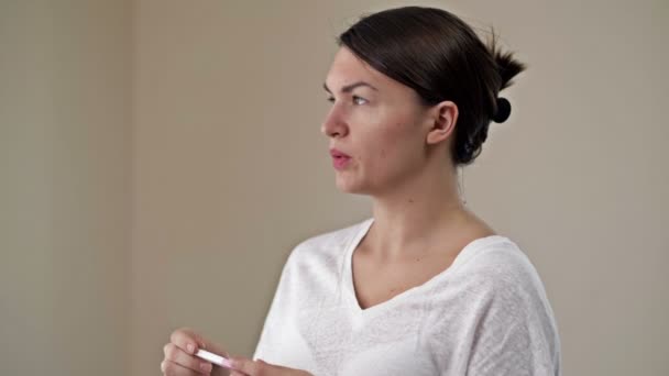La femme est bouleversée par le résultat d'un test de grossesse. Soit la grossesse est indésirable, ou les espoirs de grossesse ne sont pas devenus réalité. — Video