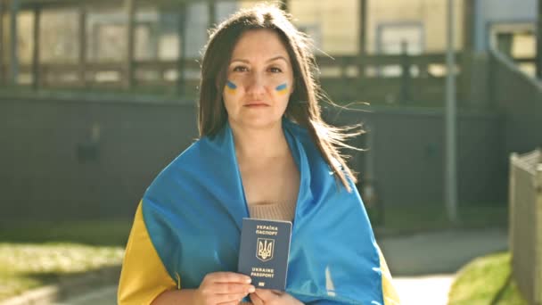Ritratto di donna coperta dalla bandiera ucraina con un passaporto ucraino in mano. Protesta contro la guerra in Ucraina e l'aggressione russa. — Video Stock