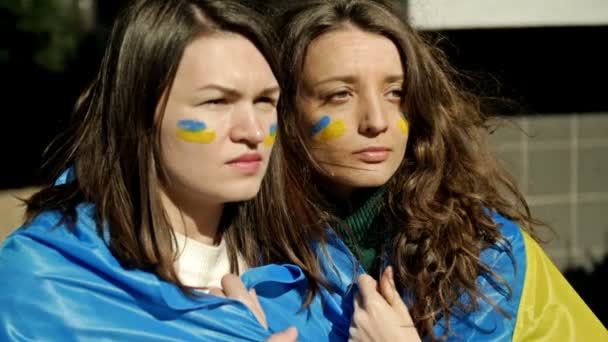 Mulheres com a bandeira da Ucrânia em seus ombros, olhando para a distância com emoção e esperança. Protesto contra a guerra na Ucrânia e agressão russa. — Vídeo de Stock