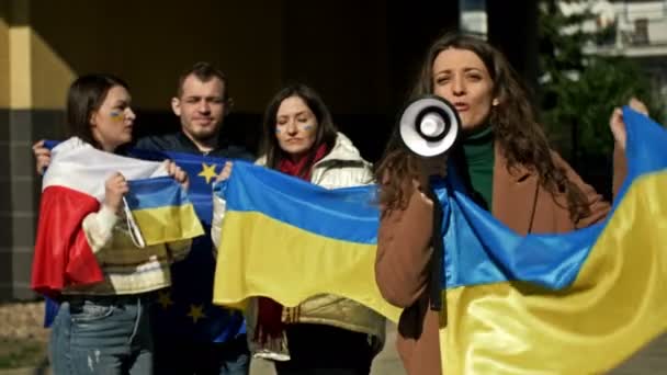 Протести проти війни в Україні та вторгнення Росії. Люди з прапорами на демонстрації на підтримку України.. — стокове відео