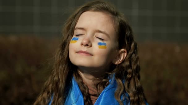Dziewczyna 9-10 lat z ukraińską flagą na ramionach. Wojna na Ukrainie. Dzieci Ukrainy. — Wideo stockowe