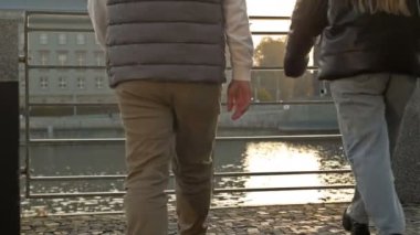 Adam ve kız nehrin ve şehrin manzarasına hayran olmak için baraj kenarındaki metal korkuluklara yaklaştı. Arka plan.