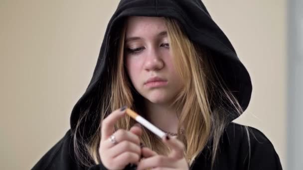 Egy tinédzser lány eltör egy cigarettát. Dohányzás elleni tiltakozás. A vágy, hogy véget vessünk a káros függőségnek.. — Stock videók