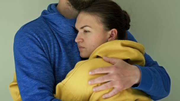 A man and a woman stand embracing in clothes of the colors of the Ukrainian flag. As a symbol of the fight against Russian aggression. — Stock Video