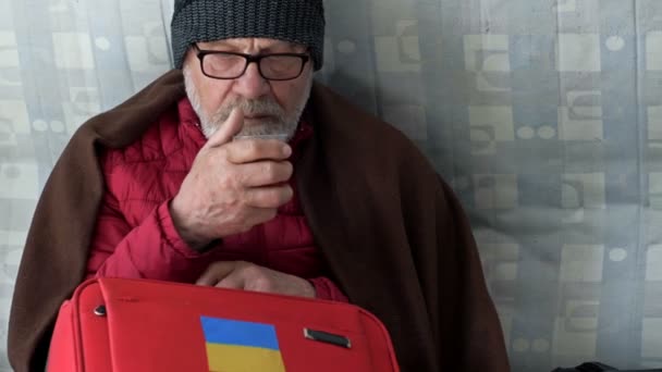 来自乌克兰的难民。一位老人和他的孙女正在重新安置中心等待帮助。俄罗斯对乌克兰的战争. — 图库视频影像