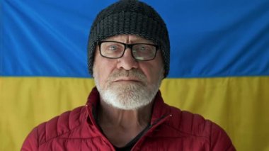 Ukrayna Bayrağı 'nın arka planında yaşlı gri saçlı bir adam var..