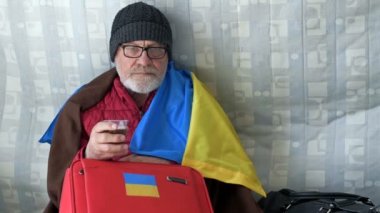 Ukraynalı mülteciler. Yaşlı bir adam ve torunu yerleşim merkezinde yardım bekliyorlar. Rusya 'nın Ukrayna' ya karşı savaşı.