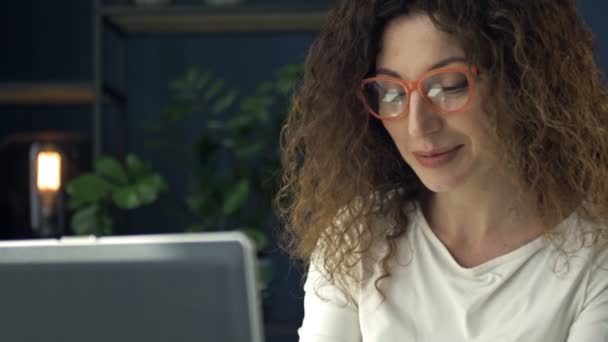 Retrato de una mujer de mediana edad trabajando en un portátil. Ella está enfocada y pensativa. Trabajo a distancia. — Vídeos de Stock