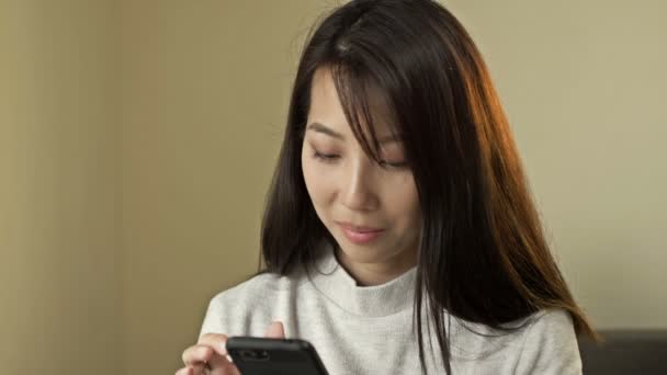 Portrét mladé asijské ženy s mobilním telefonem v rukou. — Stock video